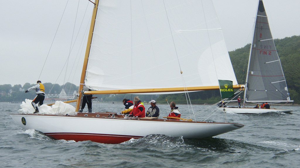 Klassische Holzyacht mit weißem Rumpf unter Segeln auf der Förde
